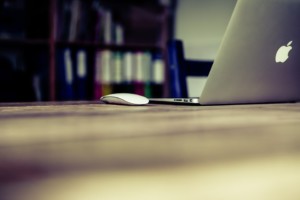 An unoccupied Apple laptop sits on a desktop