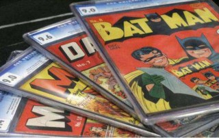 Four collectible comics spread out with Batman comic on top