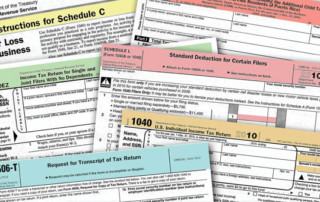 Various tax forms spread out across image